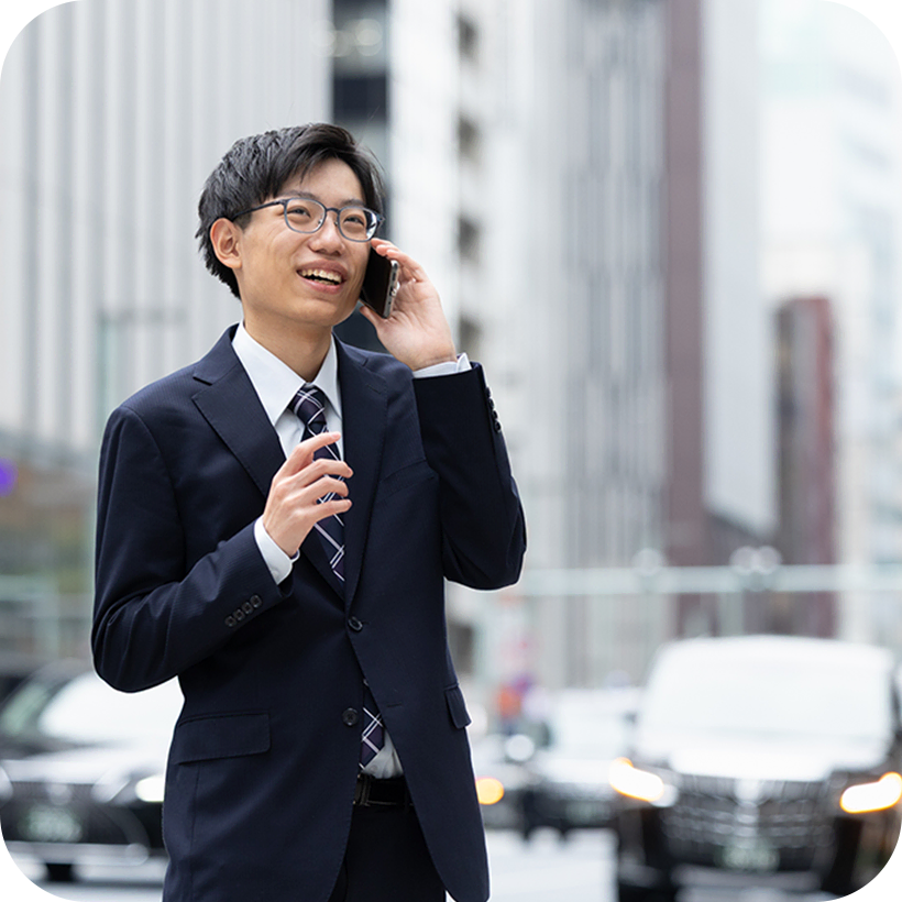 街中で携帯電話を使って話しているY.K.さんの様子