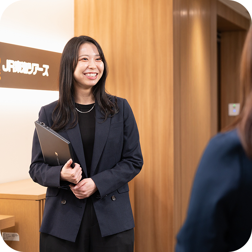 社内で同僚と立ち話をするR.M.さんの様子